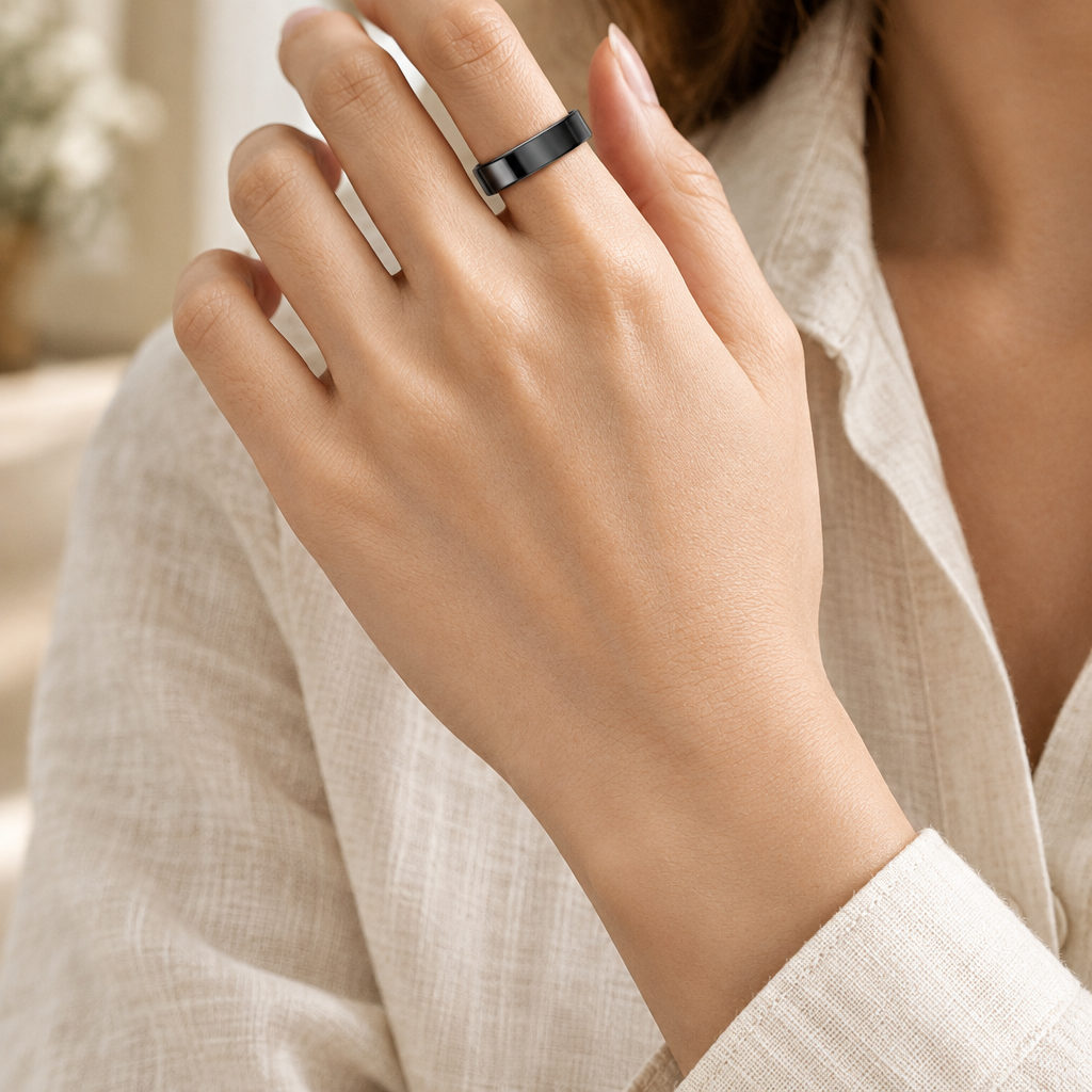 Black smart ring worn on an adult hand